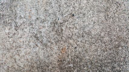Close-up stone or concrete rough surface texture with mixed light and dark coloration  