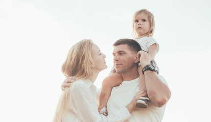 family with a little girl and a dog on the background of the sky