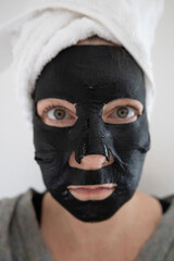 Schwarze Gesichtsmaske für Feuchtigkeit im Gesicht am Wellnesstag