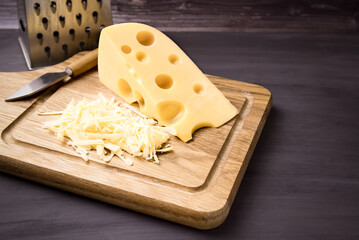 Fresh cheese on a wooden board. On black background.