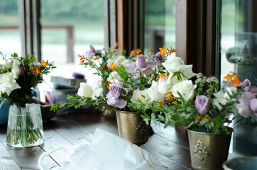 Preparing wedding bouquets for the celebration. Different flowers in pots on the table in the interior, selective focus,