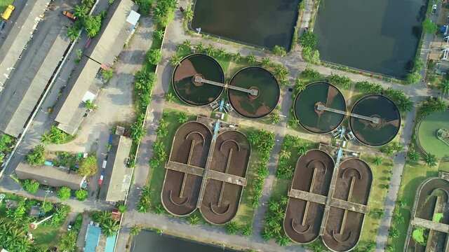 Aerial view High angle view Top down drone shot of the sewage treatment plant.The Solid contact clarifier tank type sludge recirculation in water treatment plant. Industrial wastewater treatment plant