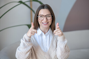 Long-haired woman in eyeglasses smiling nicely and looking contented