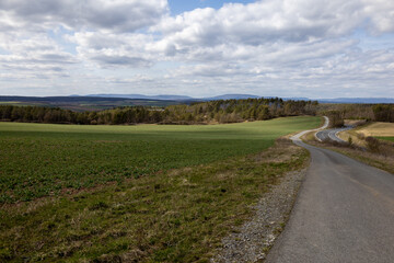 Fototapeta premium Ferner Blick über eine Landschaft mit Straßen und Windrädern am Horizont