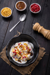Indian tasty street food Dahi Bhalla or  Dahi Vada garnished with tamarind sauce and pomegranate seeds 