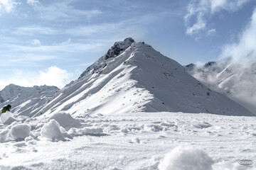 Fototapeta na wymiar Mountain Peak Covered in Powder Snow on Clear Day
