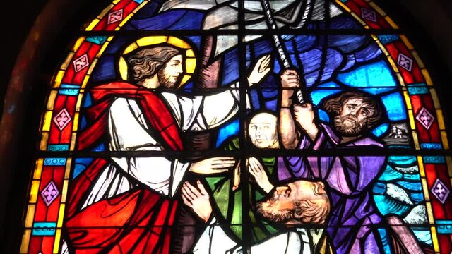 Italy , Milan march 2021 stained glass window of a Christian church with colored glasses depicting scenes of the spirituality of the Catholic religion in San Cristoforo church