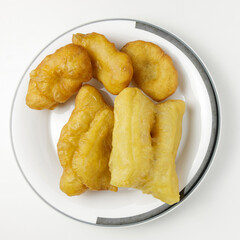 Deep-fried dough stick on a white dish isolated on a white background. Top view photography. The popular breakfast of the Thai.