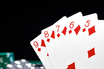 Poker chips and playing cards on black background