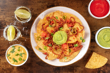 Nachos with tequila and dips, overhead flat lay shot