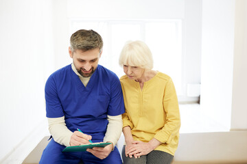 Senior woman patient during a consultation with her male physiotherapist at a wellness rehab center