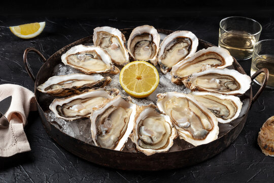 Oysters on a platter. A dozen of fresh oysters with lemon
