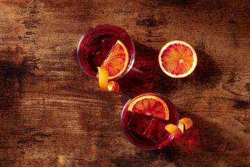 Negroni cocktail, overhead flat lay shot with blood oranges and copy space