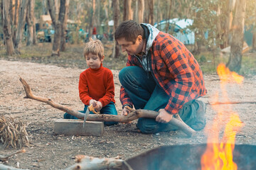 Father and son cutting a log in the forest
