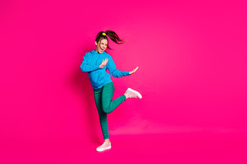 Fototapeta na wymiar Full length photo of charming cute young lady wear blue sweater dancing standing one leg isolated bright pink color background