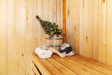 Interior details Finnish sauna steam room with traditional sauna accessories basin birch broom scoop felt hat towel. Traditional old Russian bathhouse SPA Concept. Relax country village bath concept.