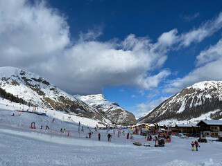 Fototapeta na wymiar Winter weekend, sunny day. Ski resort. House in the mountains. Livigno, Italy