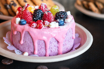 Sweet cheese cake with fresh berries and yoghurt cream. Delicious raspberry cake with fresh strawberries, raspberries, blueberry, currants and blackberry fruits on rustic wooden background.