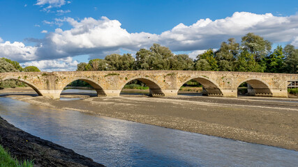 The ancient Ponte Buriano over the Arno river in the province of Arezzo, Tuscany, Italy, on a sunny...