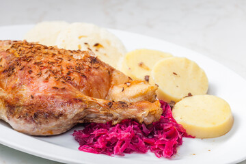 roasted goose leg with red cabbage and dumplings