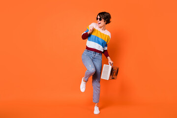 Full body photo of crazy positive lady look empty space toothy smile dancing isolated on orange color background