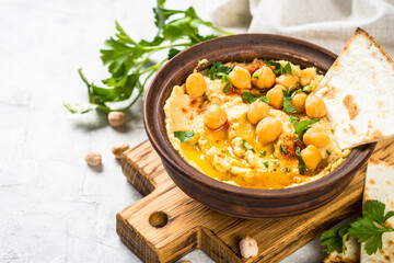 Hummus with olive oil and paprika at light kitchen table.