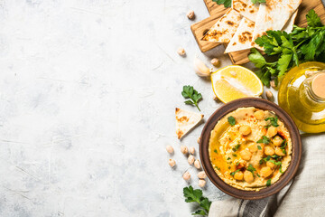 Hummus with olive oil and paprika at light kitchen table.