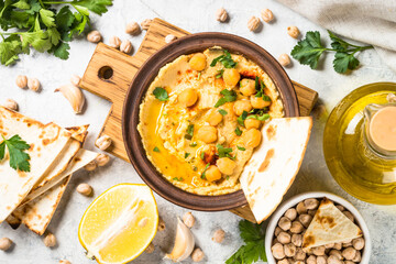 Hummus with olive oil and paprika at light kitchen table.
