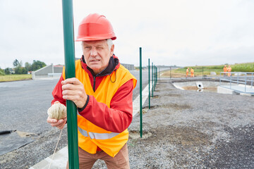Construction worker with guideline at the fence construction