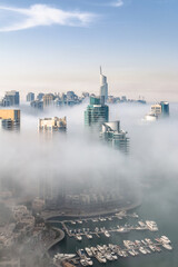 Dubai skyline, aerial top view of towers rooftops in Dubai Marina on a foggy morning