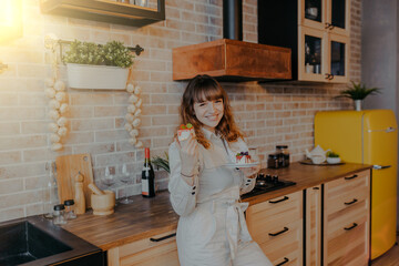Woman eats cake in the kitchen. Woman on diet eating cakes.