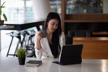 Fototapeta premium Shot of an attractive young businesswoman working on laptop in her workstation