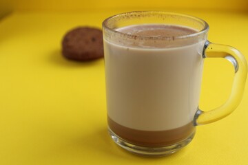 a cup of hot chocolate cocoa on a bright yellow background with room for a copyspace text