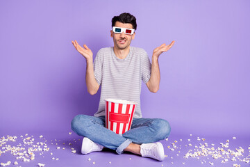 Photo of man hold box popcorn dirty floor shrug wear 3d specs white t-shirt jeans sneakers isolated...