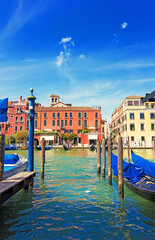 iew on the traditional boats, gondolas and colorful architecture near the ancient Rialto Bridge (Ponte di Rialto) in Venice, Italy. Soft focus