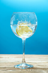 Fresh clear water with lemon and splashes on a blue background