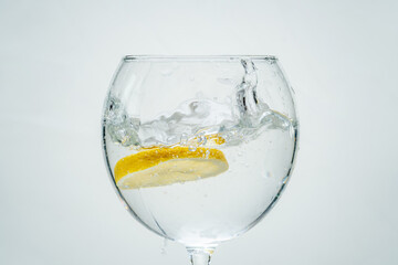 Fresh clear water with lemon and splashes on a white background