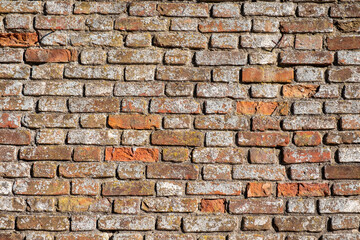 Old red brick wall in natural light.