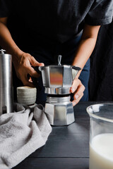 Fototapeta na wymiar Man using Italian coffee maker latte, coffee for making hot coffee into the cup with grinder equipment tool brewing at kitchen home. professional food drink