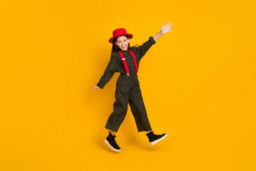 Full length body size view of pretty cheerful girl jumping having fun walking strolling isolated over bright yellow color background