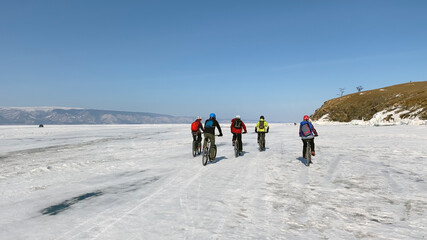 A group of cyclists on the frozen snow-covered Lake Baikal.