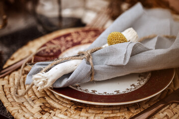 A table  designed for a boho style event with an eucalyptus, vintage plates and other rustic...