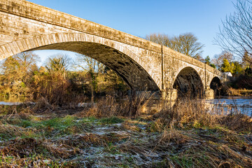 Fototapeta na wymiar The Ken Bridge on a winters day, with frost on the ground, beside the river