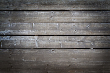 Obraz premium Natural weathered wooden boards background. Dark grey textured horizontal wood planks with nails. Copy space, vignette.