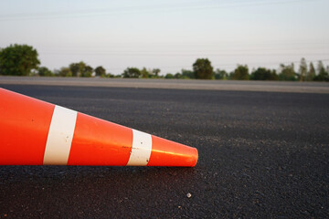 Red rubber cones are placed in the paved road.
