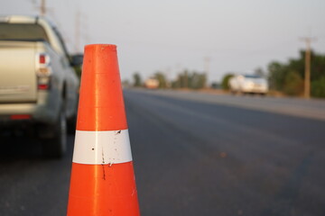 Red rubber cones are placed in the paved road.