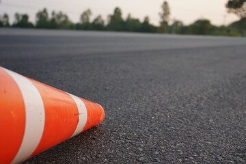 Red rubber cones are placed in the paved road.