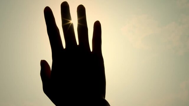 The hand picked up the sun A symbol of hope.  A hand raised to block the sunlight in summer.