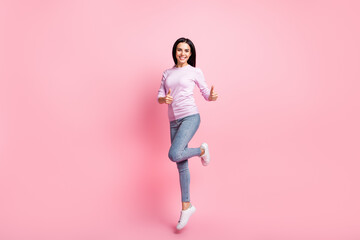 Fototapeta na wymiar Full size photo of young beautiful happy positive smiling jumping showing thumb-up isolated on pink color background