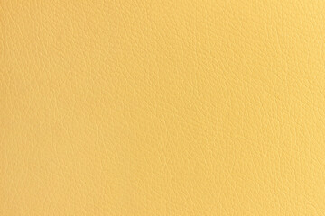 The surface of artificial yellow leather used for furniture upholstery. Uniform light texture.